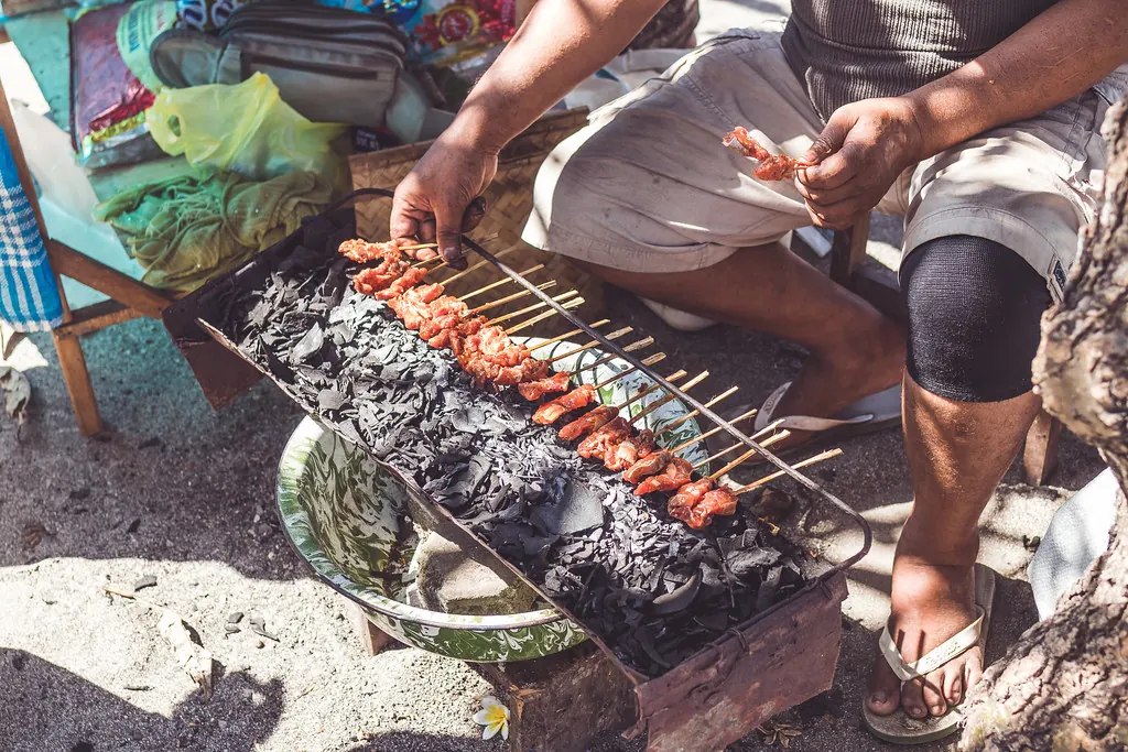 Chicken satay skewers grilling at a street stall